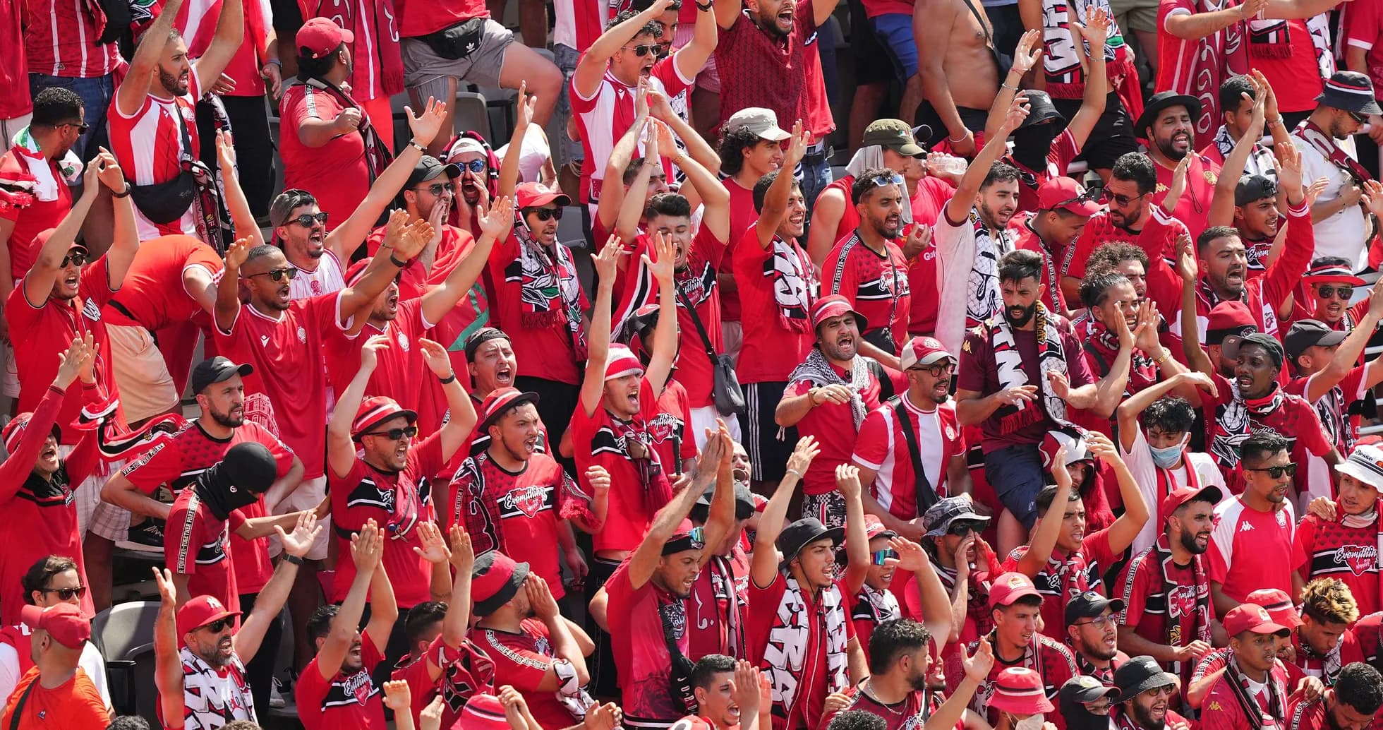 Fans in red cheering during a match