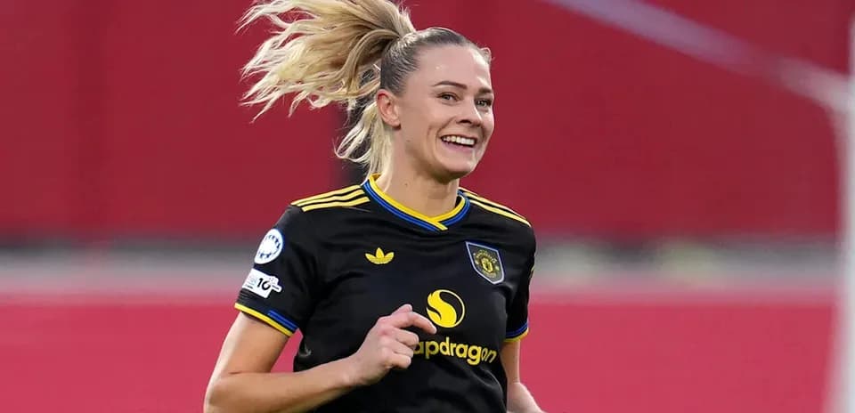 Futbolçu qara forma ilə oyun zamanı gülür