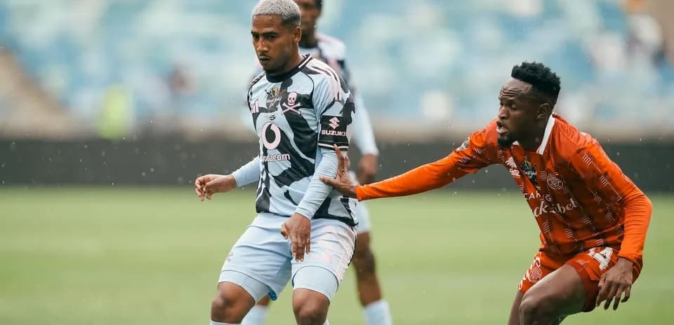 Player in blue jersey evading opponent in orange jersey