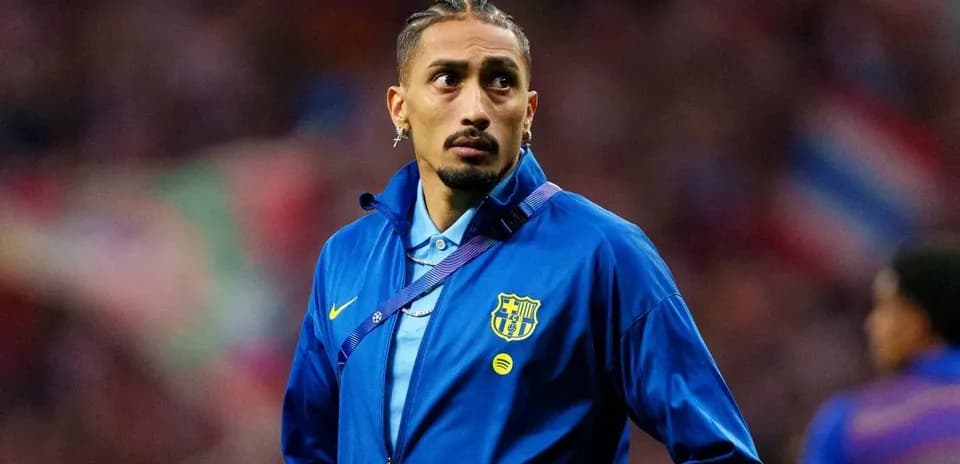 Futbolçu mavi geyimdə stadionda durur