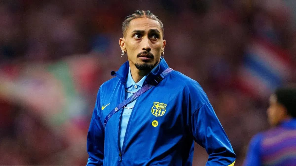 Futbolçu mavi geyimdə stadionda durur