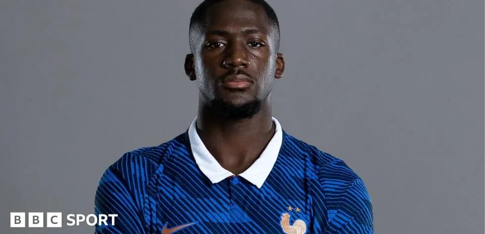 Futbolçu mavi forma ilə poz verərək durur