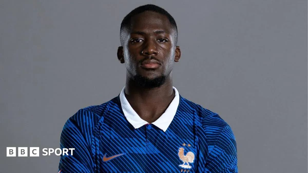 Futbolçu mavi forma ilə poz verərək durur