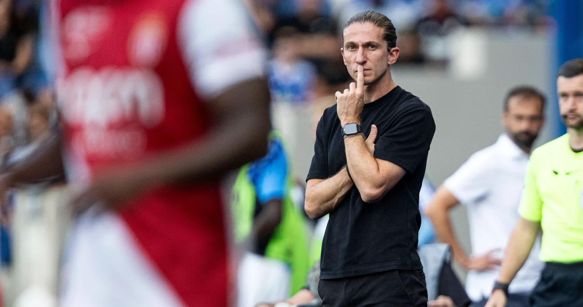 Coach observing match with finger on lips