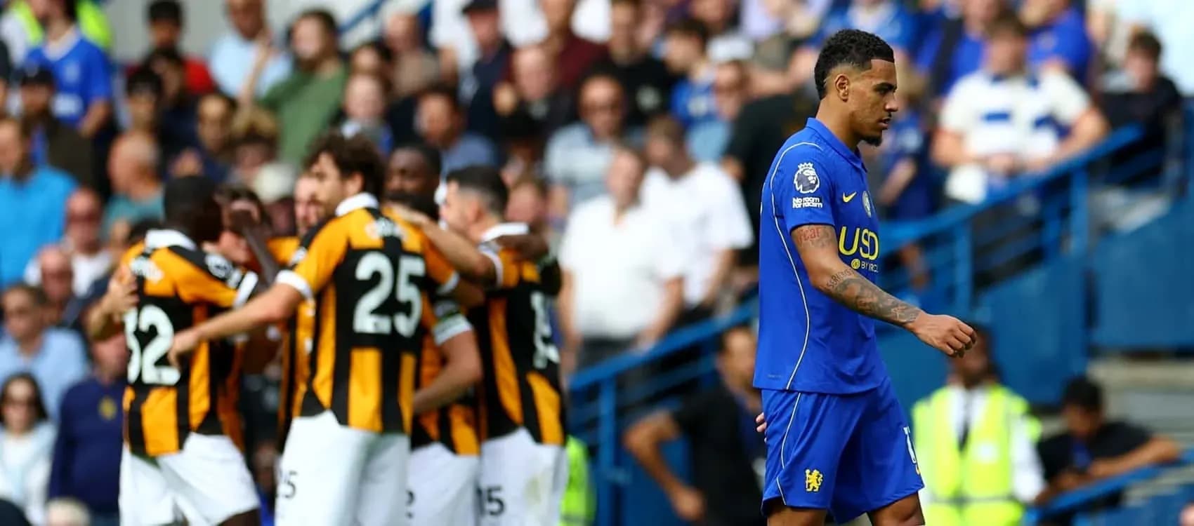 Player walking past celebrating teammates after goal