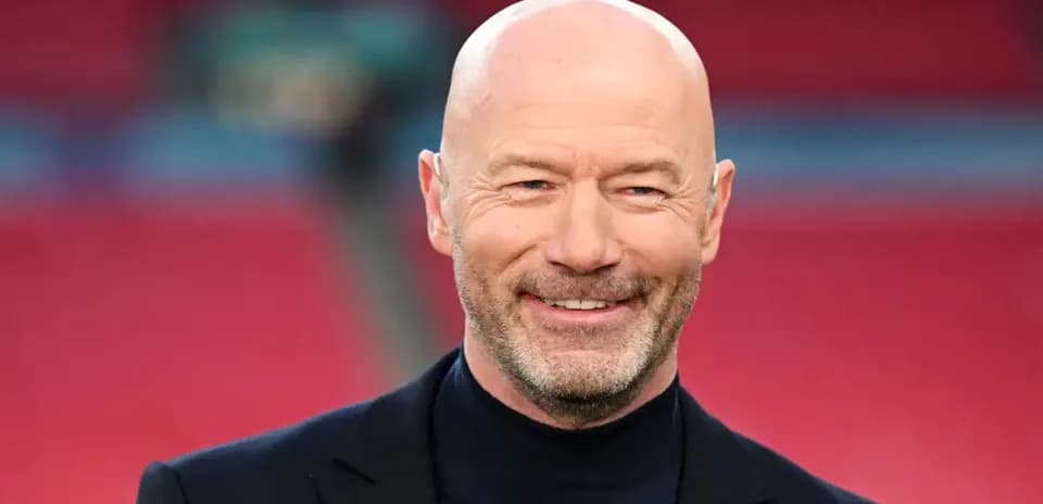 Bald man in a suit smiling at camera