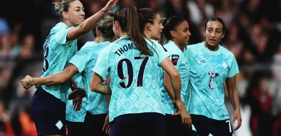 Women's football team celebrating a goal together