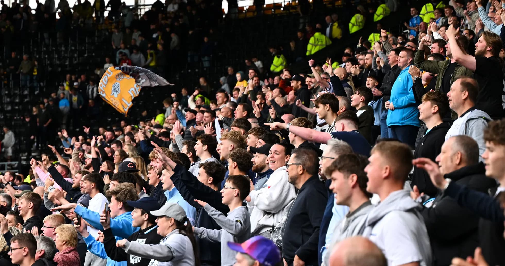 Fans cheering and celebrating in the stadium stands