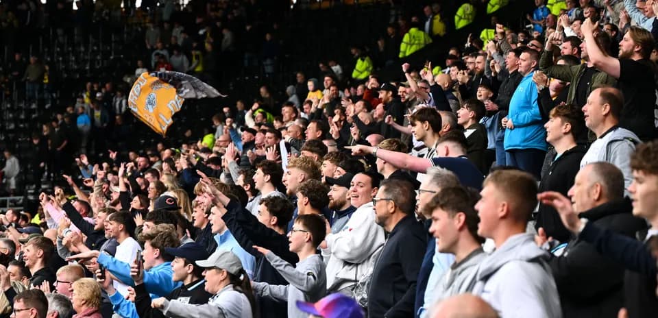 Fans cheering and celebrating in the stadium stands