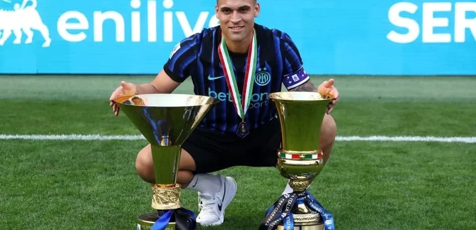 Futbolçu iki kupa ilə meydanda oturub