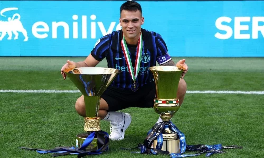 Futbolçu iki kupa ilə meydanda oturub