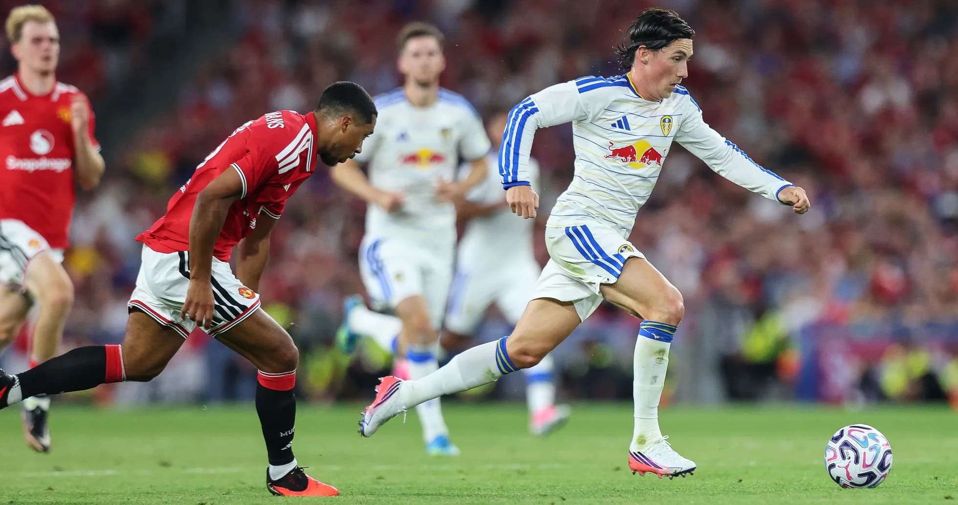 Leeds player sprinting with ball, Manchester United defender chasing