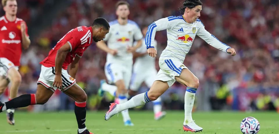 Leeds player sprinting with ball, Manchester United defender chasing