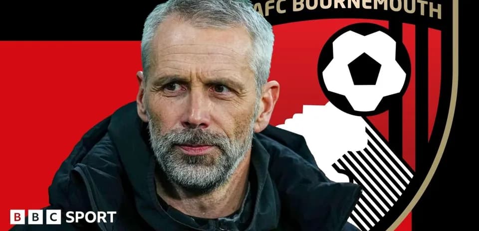 AFC Bournemouth manager in front of team logo