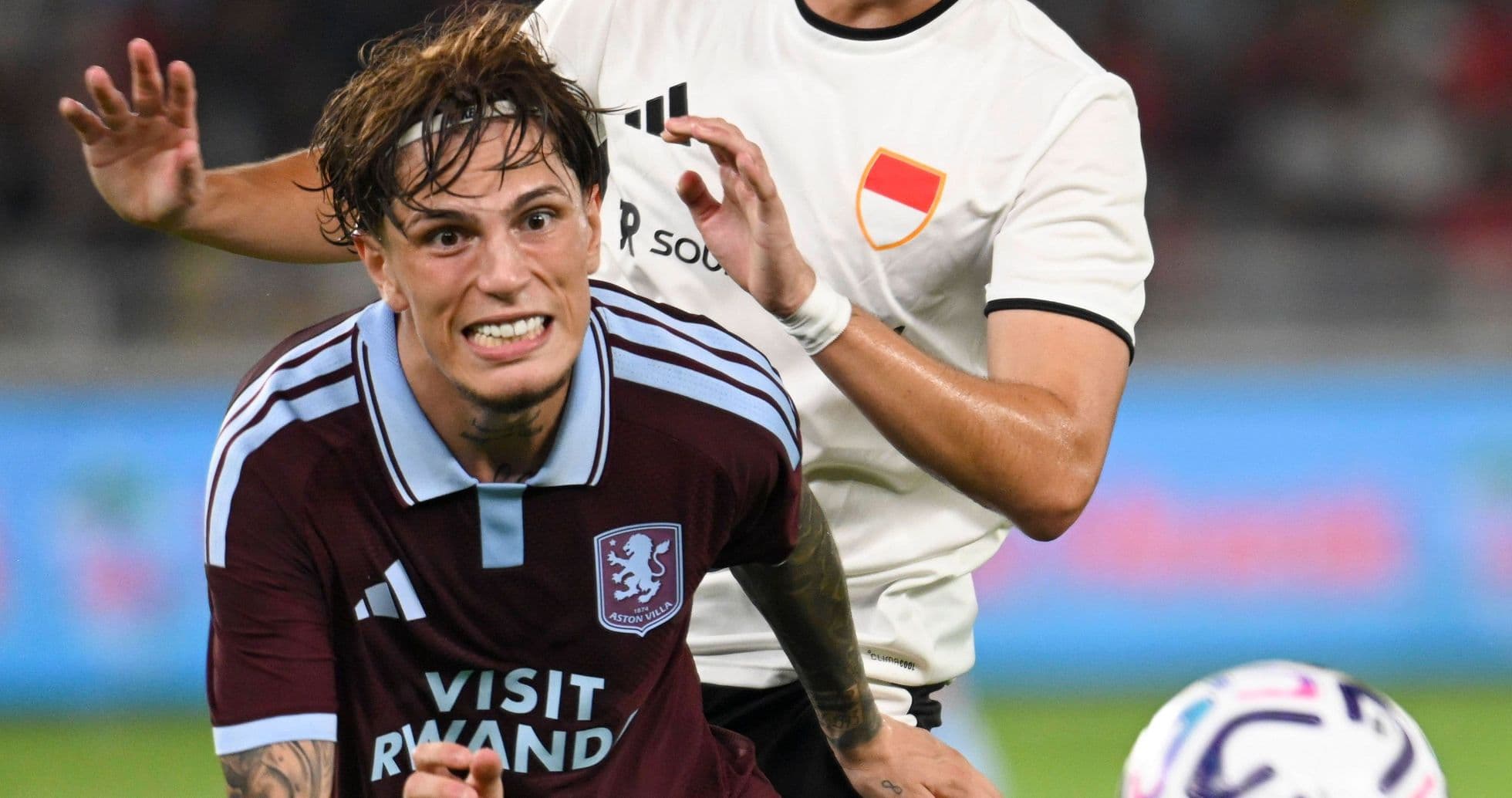Aston Villa player challenged by opponent during match