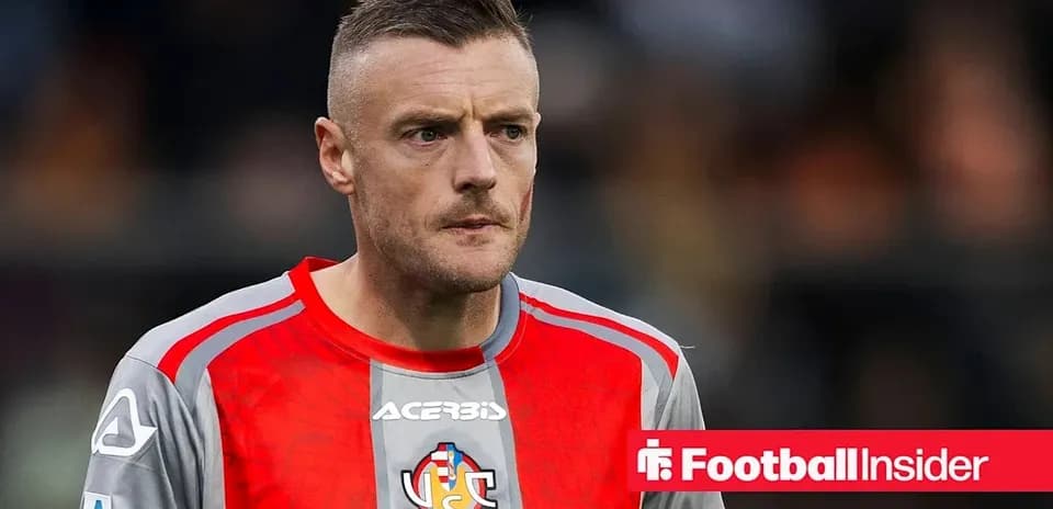 Futbolçu, qırmızı forma ilə meydanda dayanıb