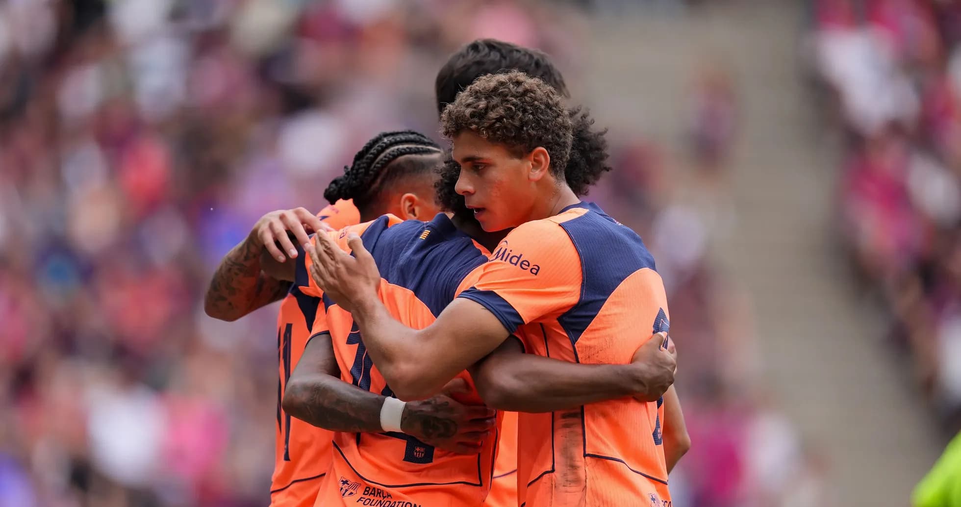 Players celebrating a goal in team uniforms