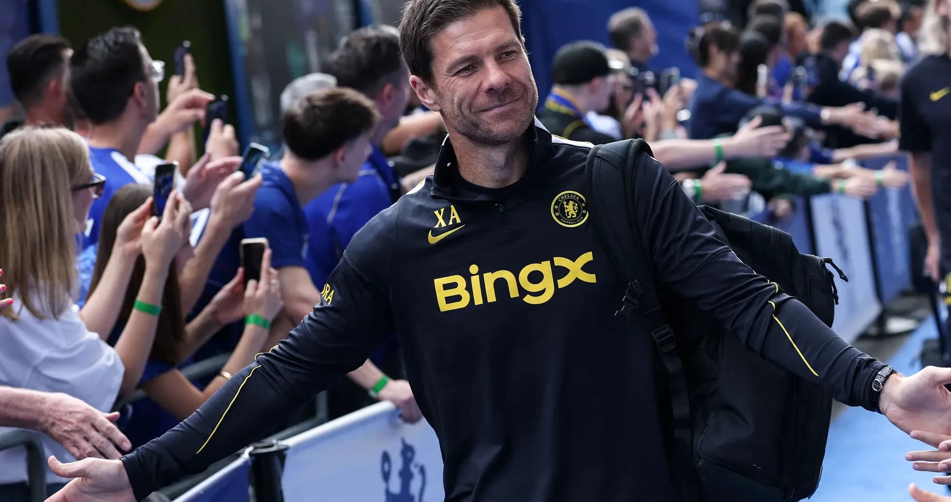 Coach greeting fans outside stadium before match
