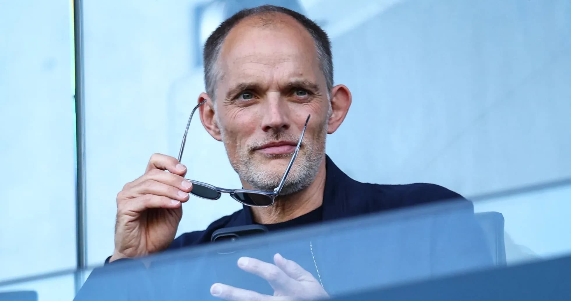 Man holding glasses while sitting in a stadium