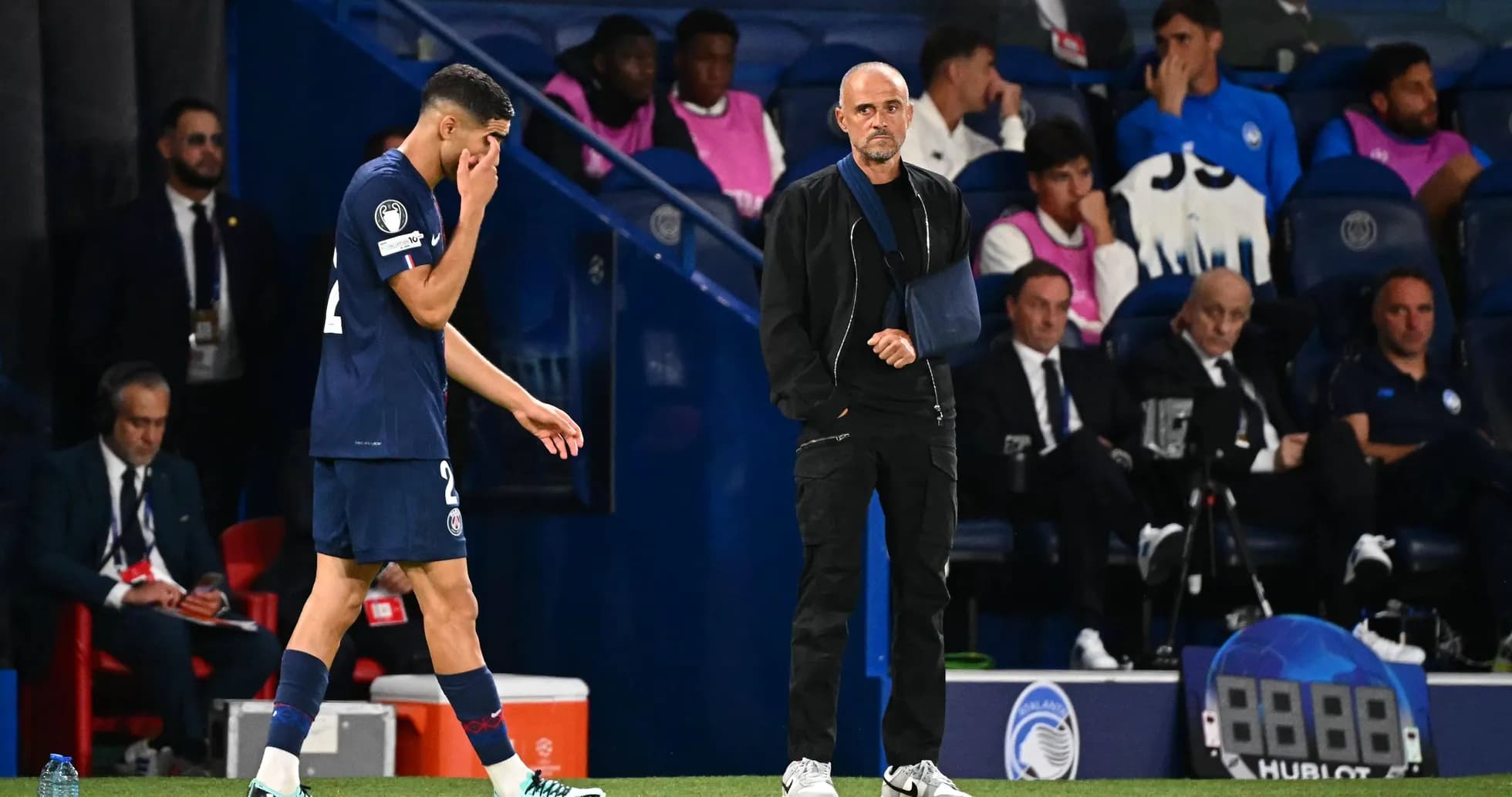PSG player leaving the pitch, coach observing closely