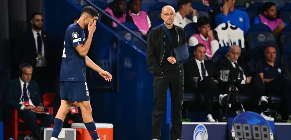 PSG player leaving the pitch, coach observing closely