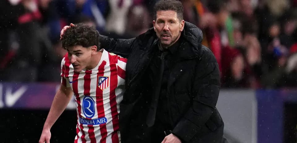 Atletico Madrid coach assisting player off the field