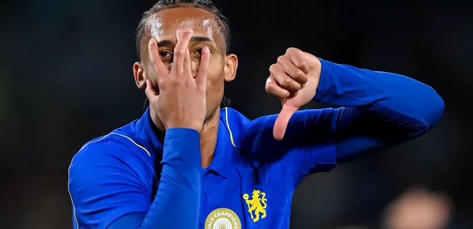 Futbolçu mavi köynəkdə əlini üzünə tutaraq jest edir