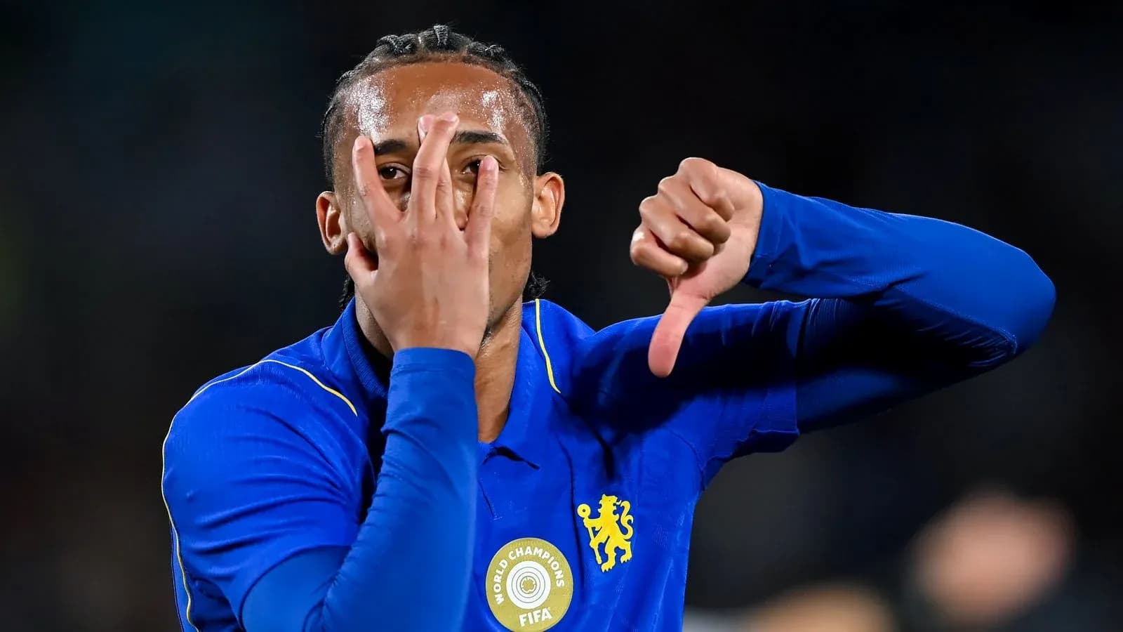 Futbolçu mavi köynəkdə əlini üzünə tutaraq jest edir