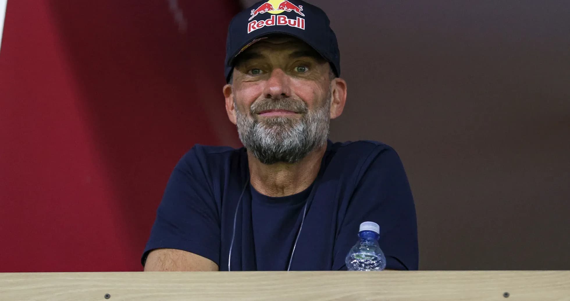 Man wearing Red Bull cap observing from a balcony