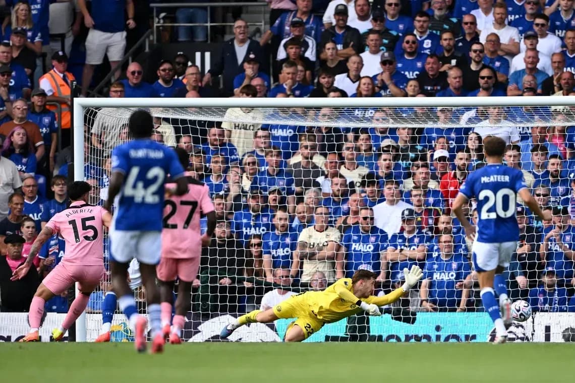 Goalkeeper diving as player takes penalty shot