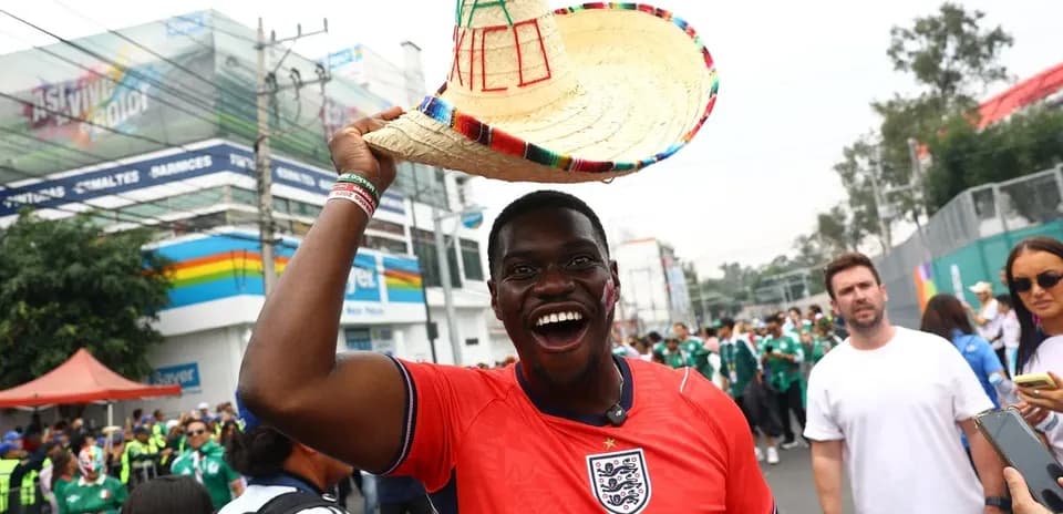 Fan in England jersey holding sombrero at event
