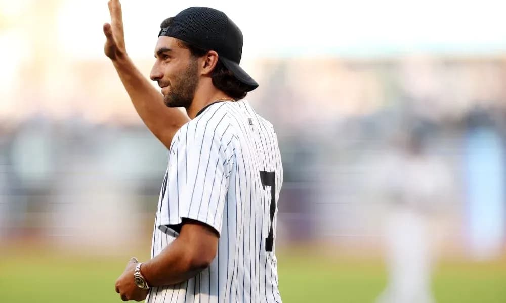 Person waving while wearing a baseball jersey