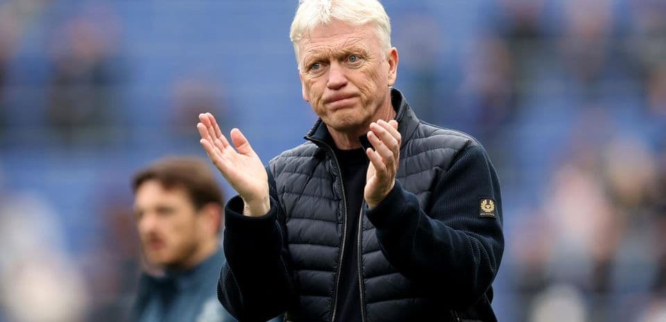 Men's football coach applauding on the sidelines