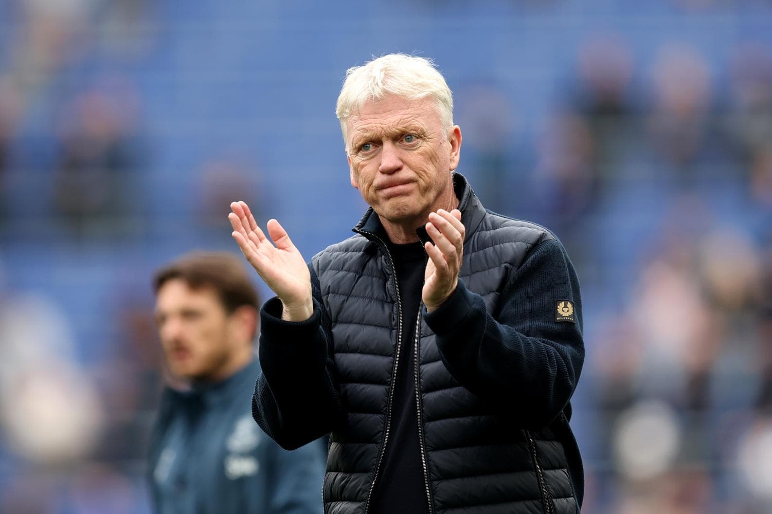 Men's football coach applauding on the sidelines