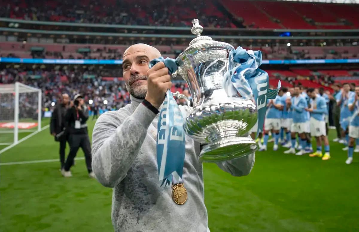 Men's football coach holding trophy at Wembley Stadium