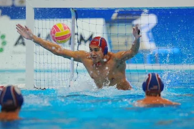 Goalkeeper attempting to block water polo shot