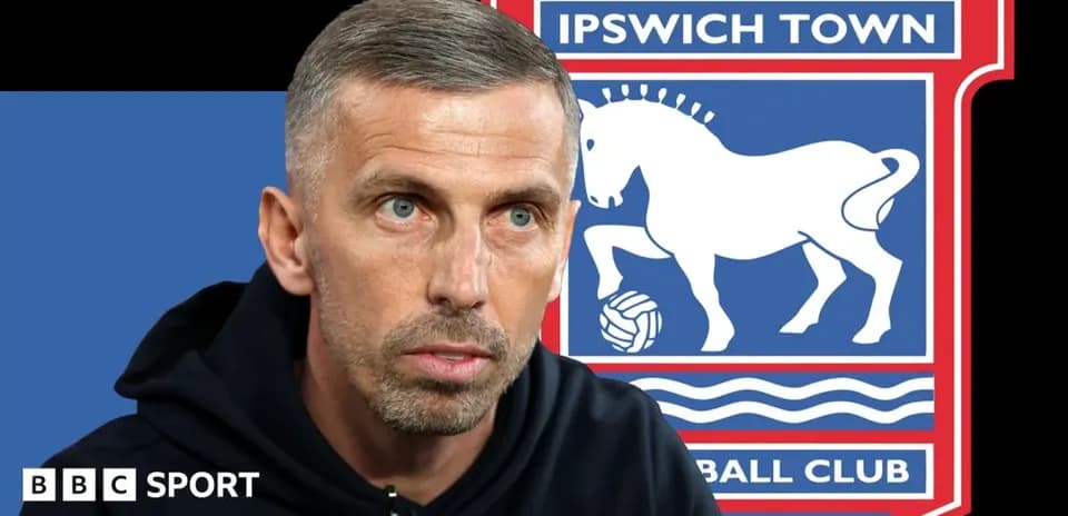 Football manager speaking with Ipswich Town logo in background