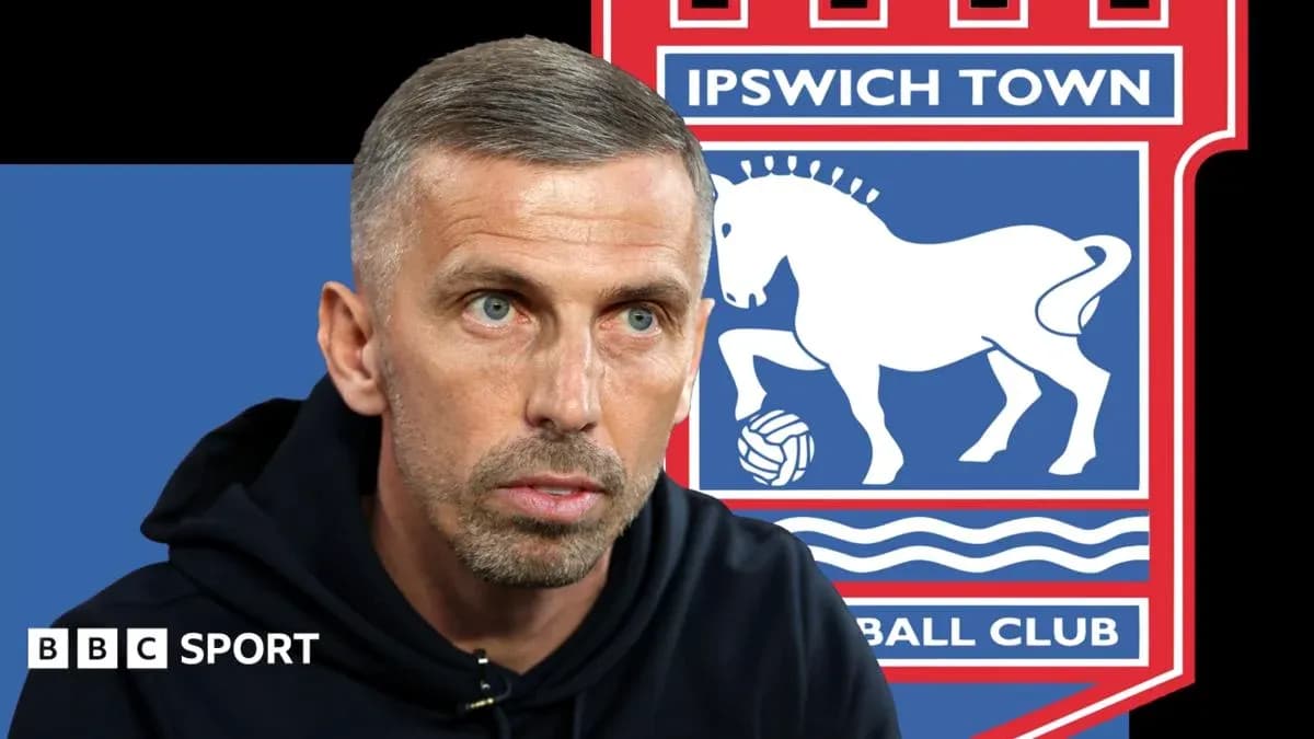 Football manager speaking with Ipswich Town logo in background