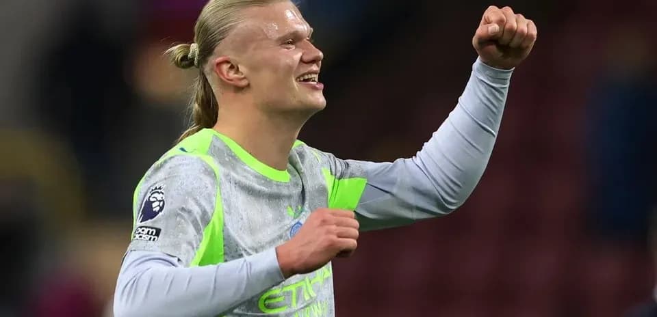Futbolçu sevinclə əlini havaya qaldırır