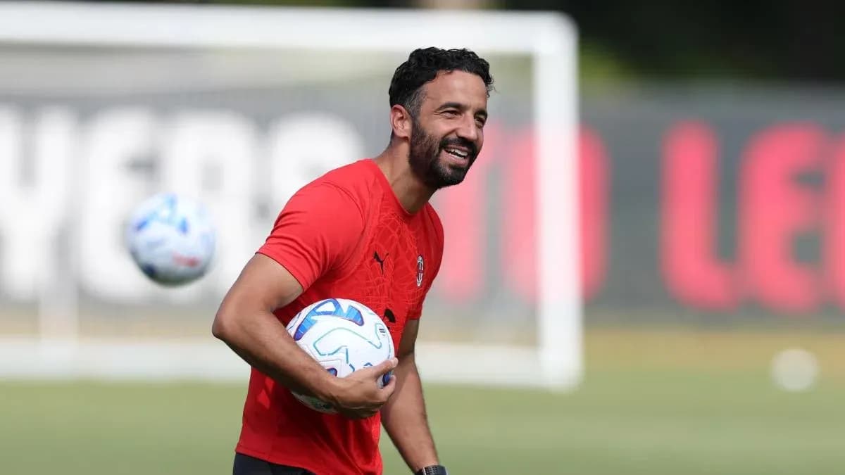 Futbolçu məşq zamanı topu tutaraq gülür