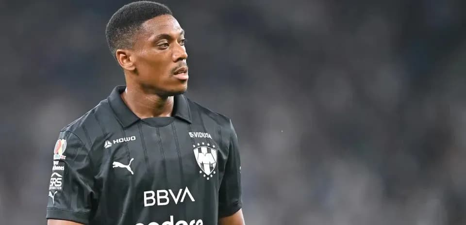 Futbolçu qara forma ilə meydanda dayanıb