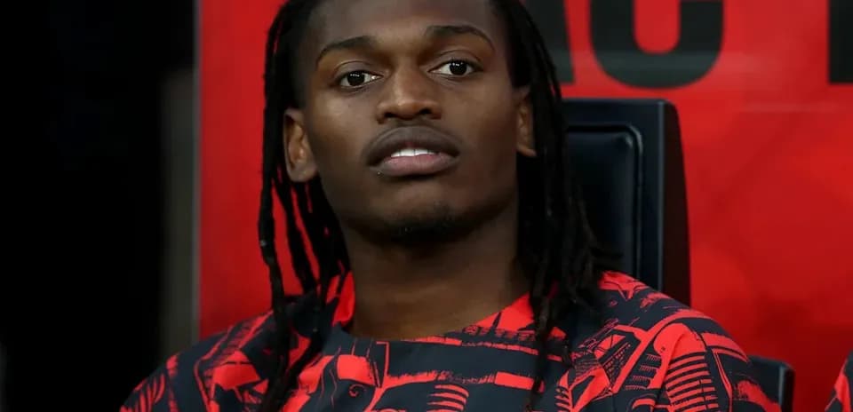 Futbolçu AC Milan formasında oturur vəziyyətdə