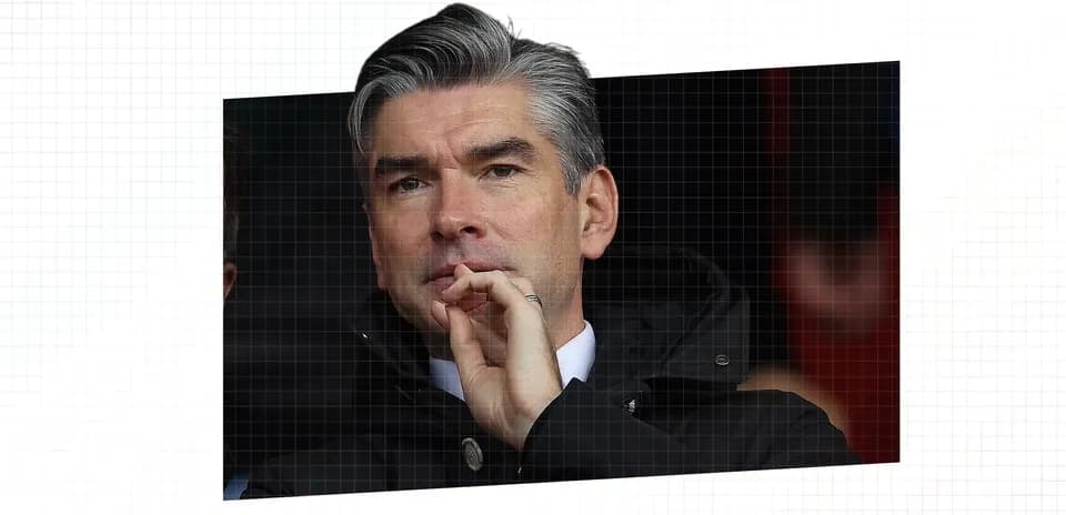 Men's football manager observing the match thoughtfully
