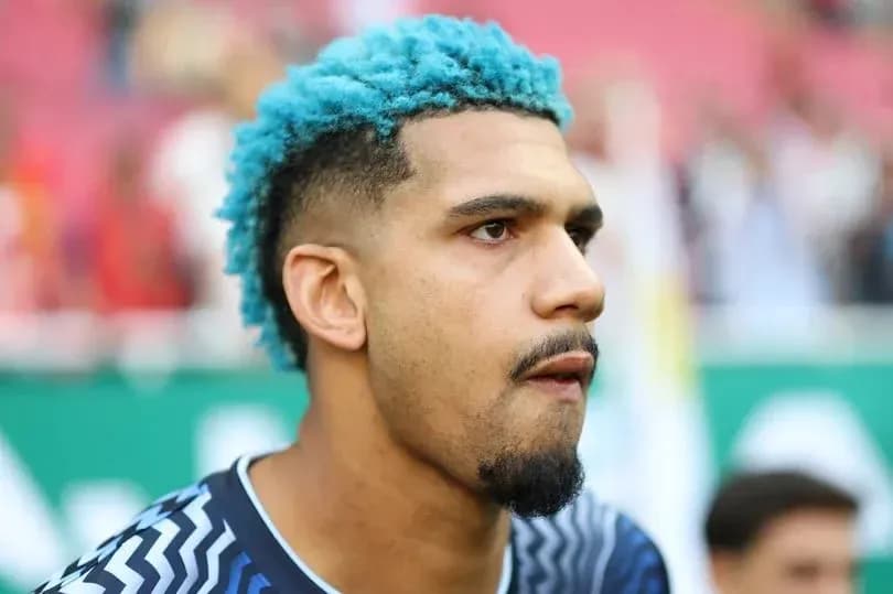 Futbolçu mavi saçla oyun öncəsi duruşda