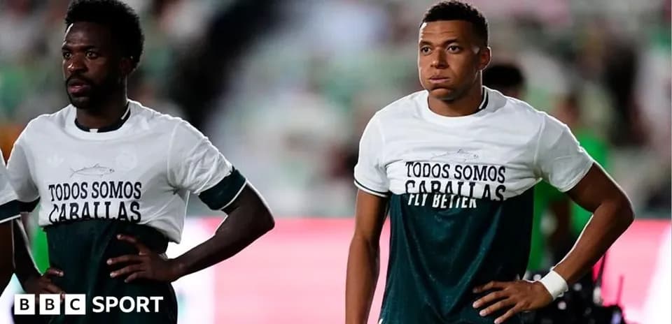 Two players wearing warm-up shirts on the field