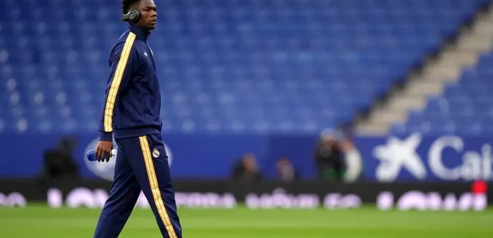 Futbolçu məşq kostyumunda stadionda yürüyür