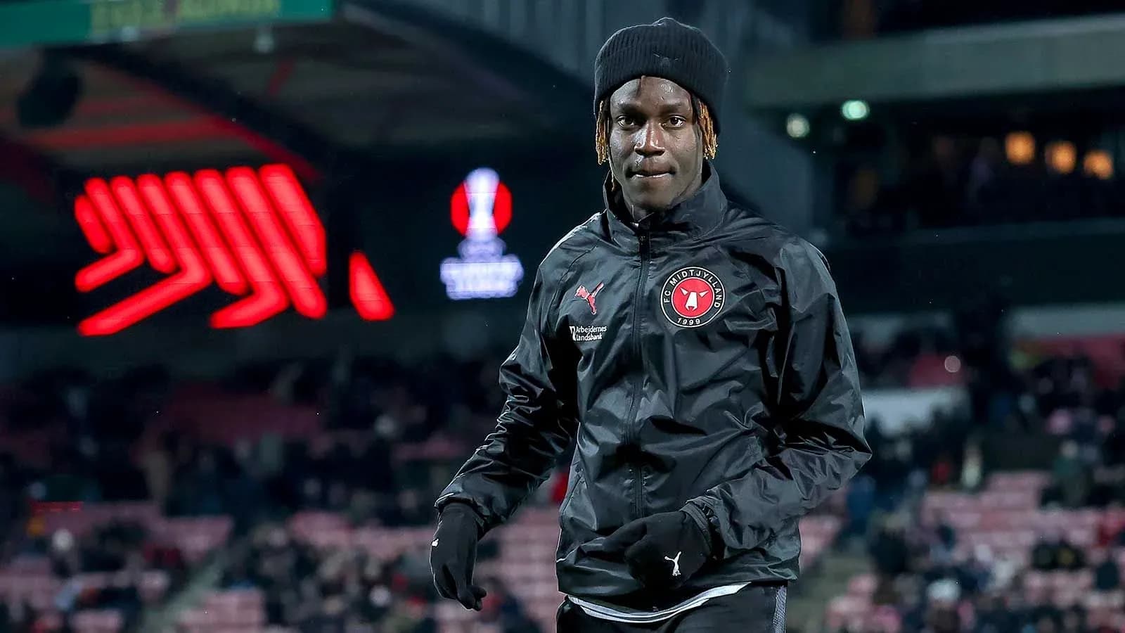 Futbolçu FC Midtjylland geyimində stadionda yürüyür