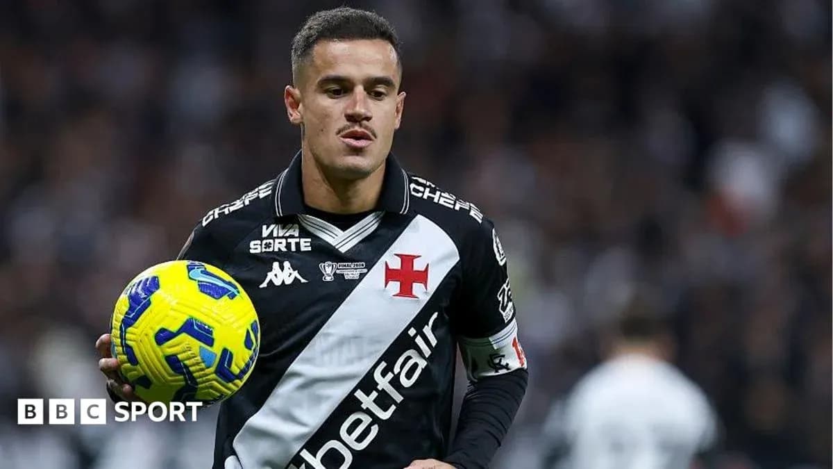 Futbolçu topu tutaraq oyun sahəsində dayanıb