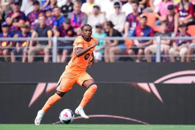 Player in orange kit running on the pitch