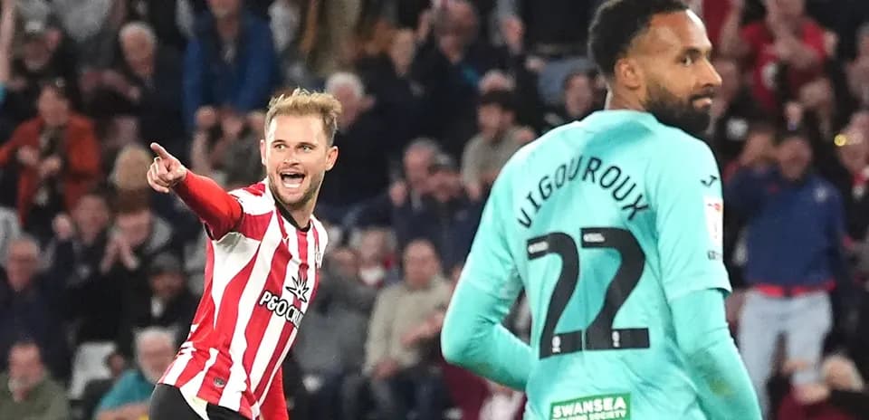 Player celebrating a goal while opponent looks on
